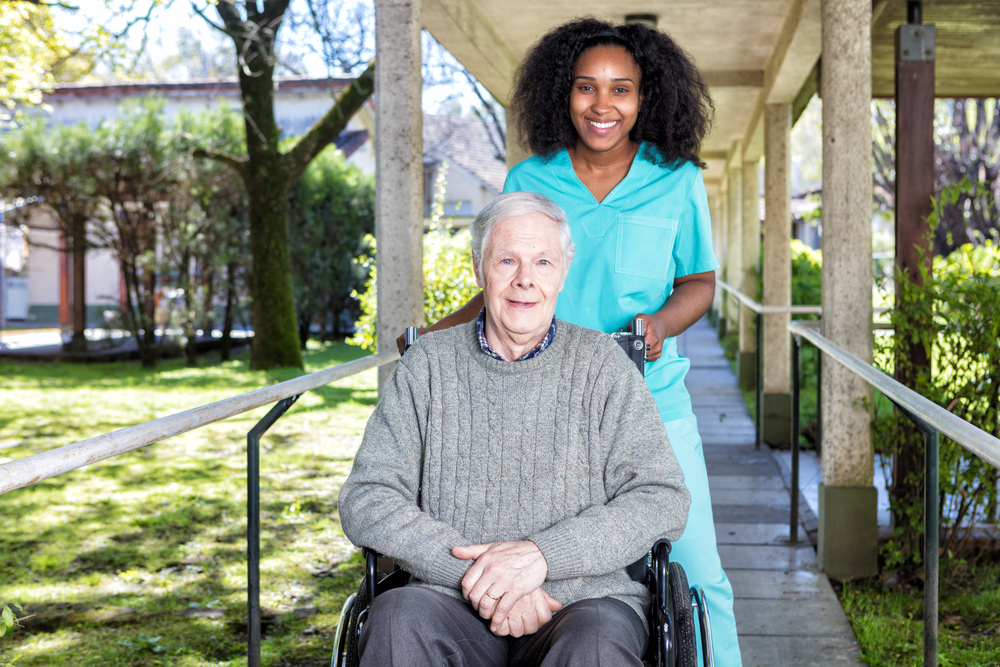 African,Nurse,Helping,Man,On,The,Wheelchair.